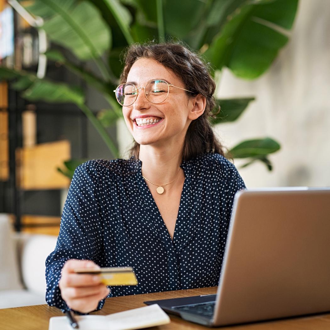 Woman smiling while working on laptop